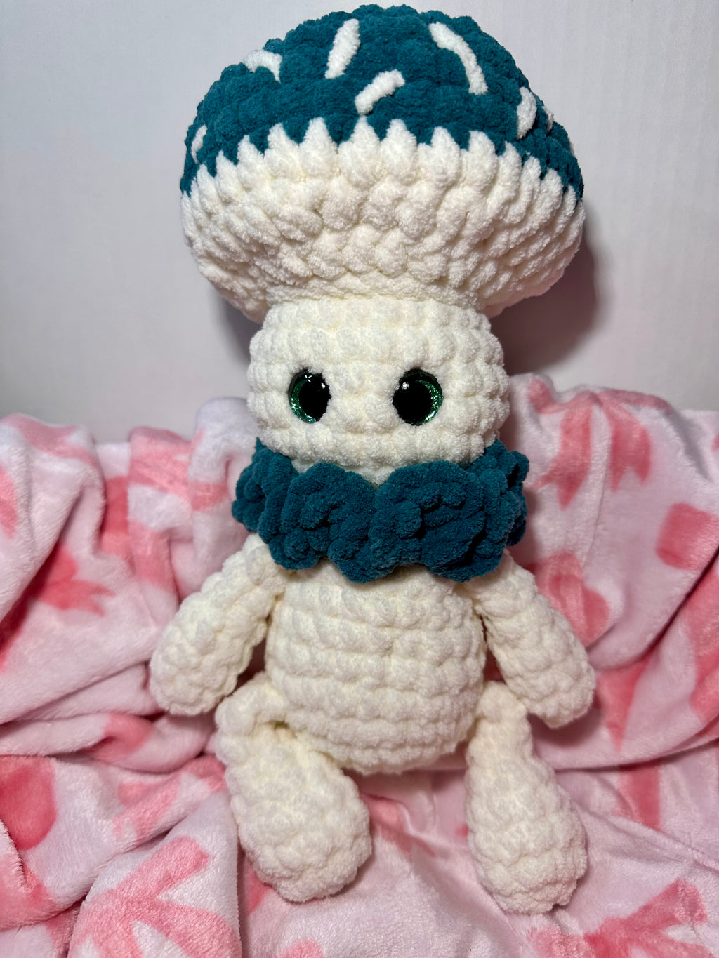 Mossy the Mushroom — handmade crochet mushroom plushie with teal cap and green safety eyes